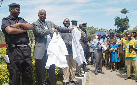 Bernard Kayumba, the Mayor of Karongi district distributes police tshirts to resident during the ongoing Police week as the DPC looks on. (Photo: S. Nkurunziza)