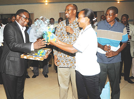 Local Government Minister,  James Musoni,(C) presents gifts to the Permarnent Secretary of Local Government and Rural Development of Malawi Patrick Kabambe(L). (Photo J. Mbanda)