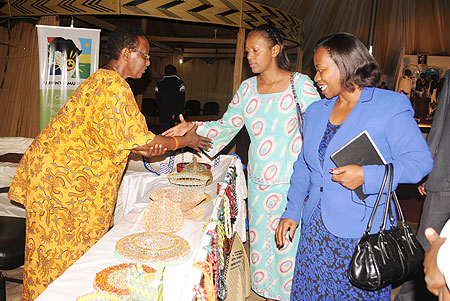 The Minister of Commerce, Monique Nsanzabaganwa and Jeanne du2019Arc Gakuba (M) talking to an exhibitor at Rwanda Village yesterday. (Photo; B. Asiimwe)