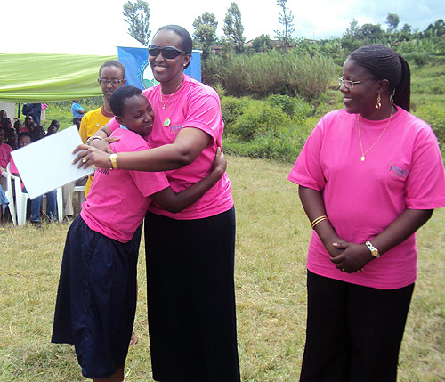 First Lady Jeannette Kagame embraces one of the students as Gender Minister, Dr Jeanne Du2019Arc Mujawamariya looks on (Photo S Nkurunziza)
