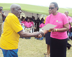 First Lady Jeannette Kagame presents a Certificate of Excellence to one of the exemplary parents on Friday. (Photo: S. Nkurunziza)