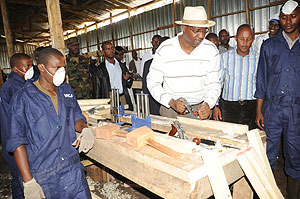 Youth Minister, Protais Mitali tries  out some of the  workshop equipment at Iwawa.(Photo J Mbanda)