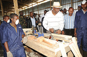 Youth Minister, Protais Mitali tries  out some of the  workshop equipment at Iwawa.(Photo J Mbanda)