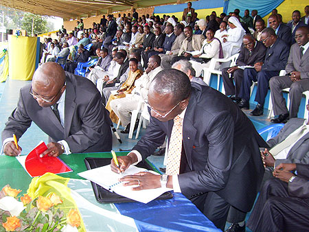 The Rector of IPB Prof Nyombayire (R) and Dr. Jean Emmanuel Djomo sign a memorandum of cooperation at Gicumbi stadium on Friday. (Photo; A.Gahene)