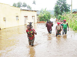 Flood victims of Musanze district fleeing their homes with their property. (Photo; B. Mukombozi)