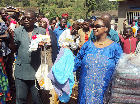 Alphonse Munyakazi, Assistant Representative of UNFPA and Beniya Izabiriza ,of PRO-FAMMES, distributing kits to flood victim in Rubavu. (Photo by R.Mugabe)