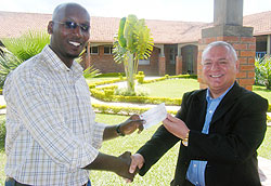 Dr Clastian Ntizimira receives the cheque from Kieran Holmes. (Photo: G. Mugoya)