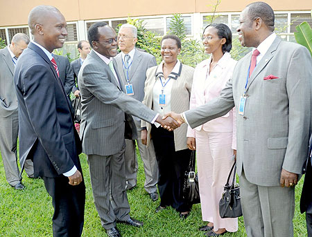 The Secretary General of Union of Producers, Transporters and Distributors of Electric Power in Africa (UPDEA) Eng. Tella Abel Didier (R) greets the General Manager Kenya Electricity Transmission, Joe Ager ,as State Minister Colette Ruhamya (2nd right) an