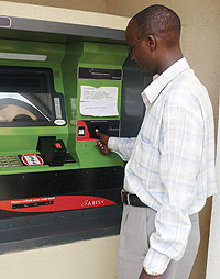 A man making a transaction at one of the ATMs in Kigali