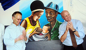 Dennis Weller (R) and Charles Lyons unveiling a  painting depicting some of the intervention measures offered at Nzige Health Center. Photo S. Rwembeho.