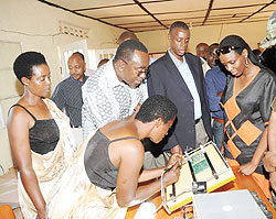WOMEN TECHNICIANS; Catherine Nyiransengimana demonstrating the assembling of a Solar battery system as the Prime Minister and other leaders look on. (Photo J Mbanda)