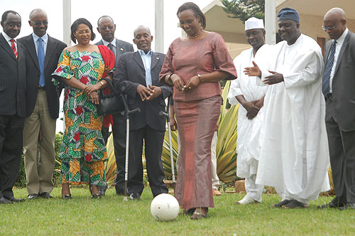 Speaker Rose Mukantabana kicks a ball to mark Rwandau2019s joining of parliamentary network on MDGs. Looking on are Rwandan and  Nigerian MPs