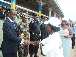 Health Minister, Dr. Richard Sezibera hands over a mobile phone to a health counselor during the Kabgayi liberation event. (Photo: D. Sabiiti)