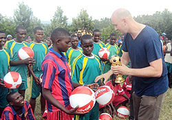 UKu2019s Daily Mirror reporter, Ryan Parry handing over a trophy to a winning team of the tournment organized as part of the newspaperu2019s outreach programmes in Rwanda. (Photo: D. Ngabonziza)