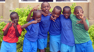 Children pose for a group photo as they send peace and love with the signs of their fingures.