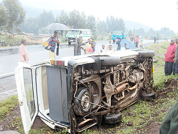 Curious residents staring  at the minibus which overturned after the accident. (Photo: B. Mukombozi)