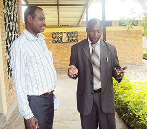 Karongi District director of finance and administration Deo Bitegetsimana (R) chats with Rubengera TTC director Gervaif Mukiza after the training session.
