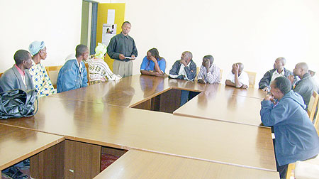 IRIBA Microfinance Manager Jean Baptiste Niyibizi reading out names of loan defaulters  at Gicumbi District hall on Monday. (Photo: A. Gahene)