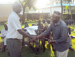 Governor Ephraim Kabaija handing over motorcycle keys to Hussein Ruhumurambuga. (Photo: S. Rwembeho)
