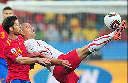 Switzerlandu2019s midfielder Gokhan Inler clears the ball under pressure from Xabi Alonso.