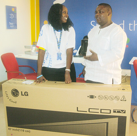 Oscar Gaterwa (R) shares a word with Tigou2019s Marketing Manager Nina Claudia Ndabaneze shortly after receiving his 47 inch LG flat screen. (Photo: F. Bugingo)