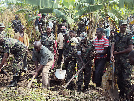 RDF soldiers joined by residents to kick start the construction of houses for the needy. (Photo; B Mukombozi)