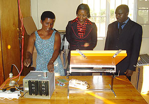 Nyirasengimana, head of the womenu2019s solar association in Bugesera District, demonstrates to Minister Collette Ruhamya how solar energy equipment operate. (Photo by Ivan R)