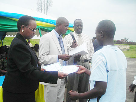 The Permanebt Secretary in the Ministry of education handing over a certificate to graduands. (Photo J Gakwaya)