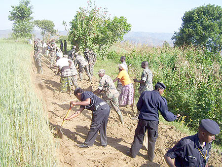 RDF soldiers in the company of the National Police and residents construct a feeder  road leading to Unity and Reconciliation village last Saturday. (Photo  / A. Gahene)