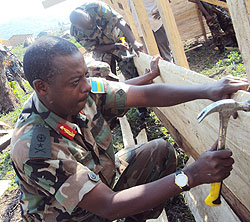 MEN AT WORK: Brig Gen Gumisiriza takes part in the house construction excercise 