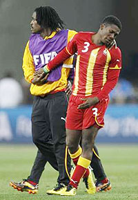 Ghanau2019s Asamoah Gyan (R) is consoled after the 2010 World Cup quarter-final soccer match.