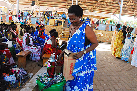 One of the women volunteers receiving a motivation package from World Vision on Tuesday. (Phot by I. Mugisha)
