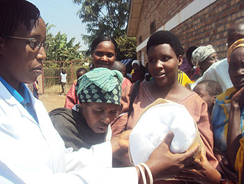 Health official giving a mosquito net to expecting mother in Rwamagana (Photo; S. Rwembeho)