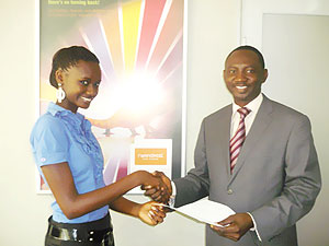 (R-L)Rwandatelu2019s CEO, Issiaka Maiga Hamidou hands over the car insurance documents to Miss Rwanda, Grace Bahati.