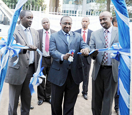 Minister Protais Musoni (C) cutting a ribbon to commission the Rwanda Press Centre yesterday. With him are Patrice Mulama and Arthur Assimwe of the MHC (Photo/ F. Goodman)