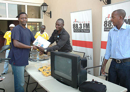 Yassin Rurangwa accepts the prize from City Radiou2019s Remmy Lubega. (Photo F.Goodman)