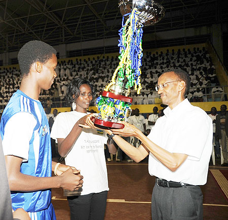 President Paul Kagame receives a trophy from the sports fraternity yesterday. (Photo J Mbanda)