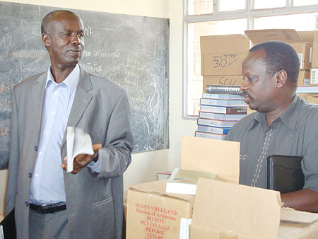 Dr. Ephraim Kabaija (L) and Dr. Eugene Ndabaga inspecting the books. (Photo: S. Rwembeho)
