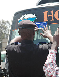 A police officer sticks an Anti-corruption sticker on a passenger van last year. Rwanda has again ranked top in the region for her stance on bribery and corruption (File Photo)