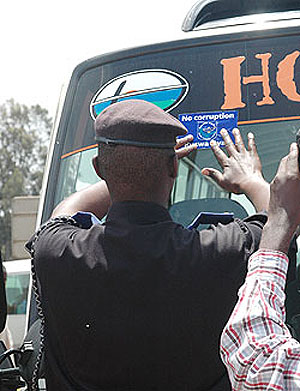 A police officer sticks an Anti-corruption sticker on a passenger van