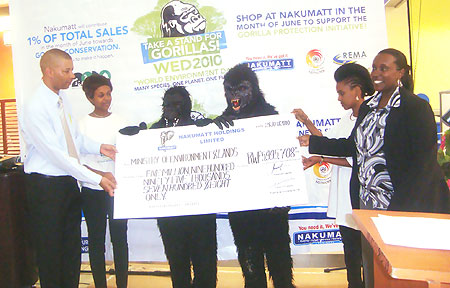 Nakumattu2019s Country Managing Director, Adan Ramata presenting the cheque to the PS in the Ministry of Environment and Lands, Caroline Kayonga.