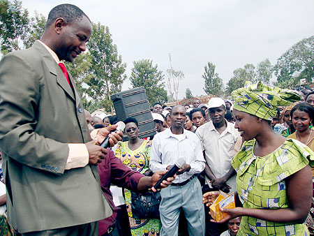 Mayor Neheme Uwimana (L) handing over a cell phone to one of the beneficiaries (Photo: S. Rwembeho)