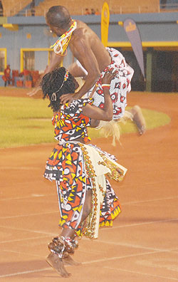 Strong Angolan woman carries a male dancer.