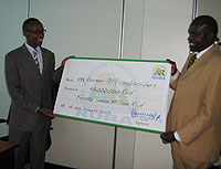 DONE DEAL; Acting DG of RURA, Regis Gatarayiha holds a dummy cheque with J. Kapukha of DN International. The money is meant to compensate all former GTV subscribers (Courtesy Photo)