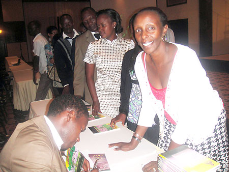 Bamporiki signs autographs after the launch of his book.