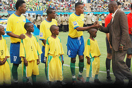 Minister Joseph habineza (R) greets Amavubi Stars captain Patrick Mafisango before the 2010 CAN qualifier with Zambia. (File photo)
