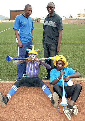 Emmanuel Ruremesha(L) and Rayon Sport Secreatry General Olivier Gakwaya with two passionate fans of the club at Regional Stadium last season.(file photo)