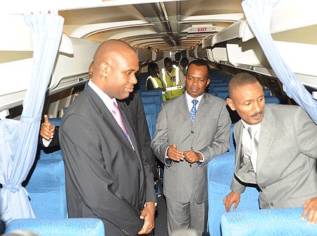 Rwandair board chairman, John Mirenge (L) and Minister of Infrastructure, Vincent Karega (C), check out one of the planes acquired under the GECAS deal (Photo / F. Goodman)