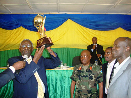 NEC Chairman, Chrysologue Karangwa,  handing over the trophy to Governor Ephraim Kabaija ( Photo by S. Rwembeho)