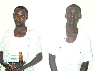 Ruzindana, holding some of substances used in making counterfeit currencies and Matabaro at the CID headquarters (Courtesy photo)